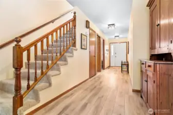 Another view of the front door, stair way leads to upstairs loft area. The whole main floor has been updated with  LVP wood flooring.