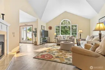 Living room with high vaulted ceilings, gas fireplace & big windows