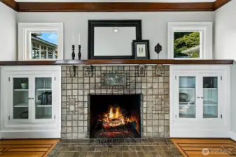 The original tile fireplace gracefully framed with glass bookshelves.