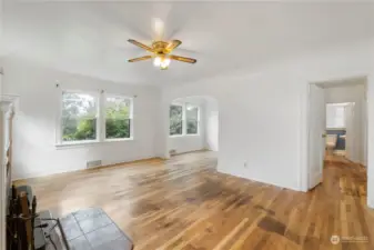 Looking from front entry. doorway to the right leads to main floor bedrooms, bath and stairs up and down. You can loop around to the kitchen also. Left archway is the dining room.