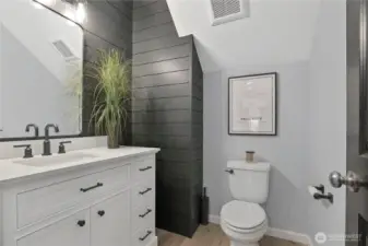 Nicely appointed powder room has been updated with painted shiplap details.