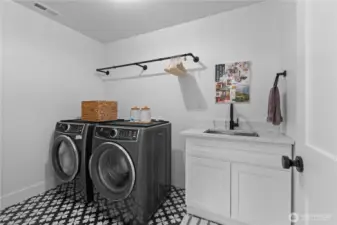 Large laundry room with sink and storage upstairs.