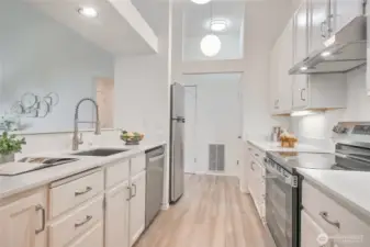 Updated Kitchen with all new stainless appliance suite, faucet, sink, hardware, luxury vinyl plank floors and granite slab countertops.