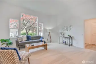 Living room with high ceilings, vinyl windows, easy access to front door and garage.