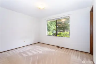 Primary bedroom, overlooking front of parcel; at right, door to primary 3/4 bathroom