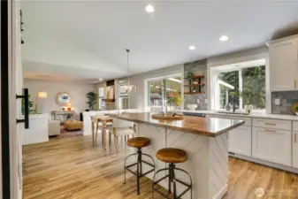 Around the corner is the stylish chef's dream kitchen with dining area and recreation room - the heart of the home. Vaulted ceilings, large sliders and updated lighting make this area bright and beautiful!