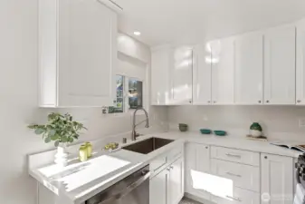 Bright, efficient kitchen workspace with quartz counters, new cabinetry, and warm quality luxury vinyl plank flooring.
