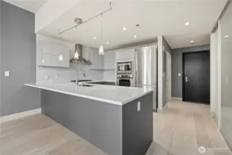 stunning new oversized quartz peninsula, new wide plank wood floors, new pedini modern cabinets