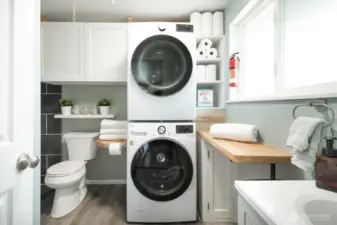 A guest-friendly bathroom and functional utility room are thoughtfully positioned off the kitchen for easy access and daily use.