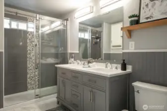 Enjoy a dual-sink vanity and timeless wood detailing that adds warmth and character to the walls.