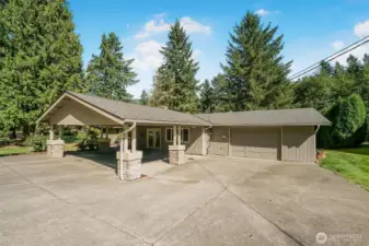 Covered front porch and Carport includes parking for 2 cars plus attached heated 2-car garage/shop.