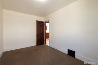 Same room (unstaged) as previous virtually staged bedroom with carpet.