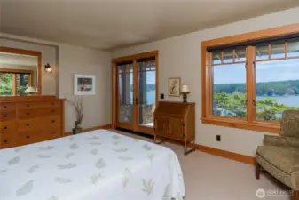 Main floor primary bedroom has built-in dresser and French doors to the patio.
