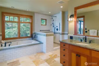 Main floor primary bathroom includes jetted tub and spacious shower.