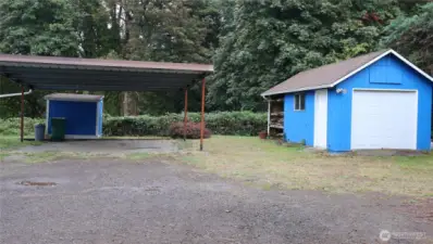 Large carport plus a single car garage and garden shed.