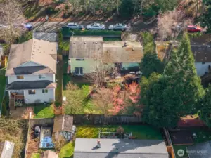 Aerial view showcasing the backyard, surrounding homes, and established neighborhood setting with mature trees.