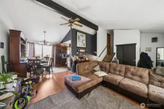 Open-concept main living area with vaulted ceilings, natural light, and seamless flow between living, dining, and kitchen spaces.