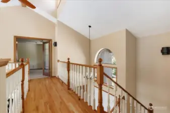 Vaulted ceilings, hardwood skywalk, and abundant natural light guide you to the primary bedroom or the second  bedroom.