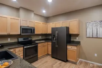 To the right of the refrigerator there is open space that is perfect for a kitchen table, or add more cabinets or pantry.