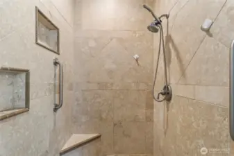 A fully tiled walk-in shower in the primary bathroom.