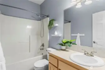 The main bathroom provides ample storage and a tub/shower.