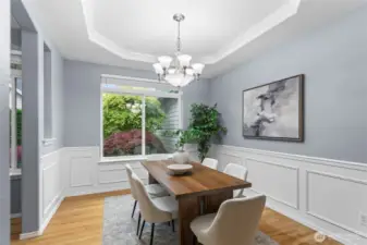 The arched entries into this space complement the coffered ceiling. A large sunny window brings light into this dining room.