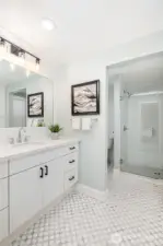 Beautifully updated primary bathroom with extra large shower, tile flooring and storage.