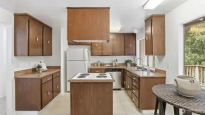 Island cooktop and generous counter space make this kitchen as practical as it is inviting.