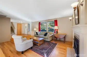 The formal living room with the front door in the background. This cozy space enjoys real hardwood floors, and a propane fireplace.