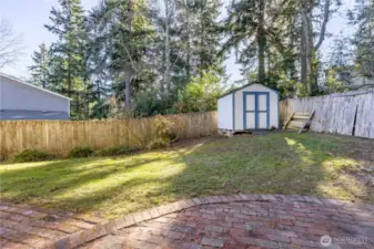 The fenced in side yard also has a medium sized shed.