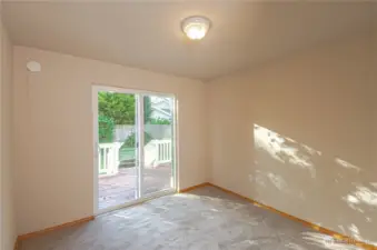 Second bedroom with sliding door that leads to fully fenced backyard