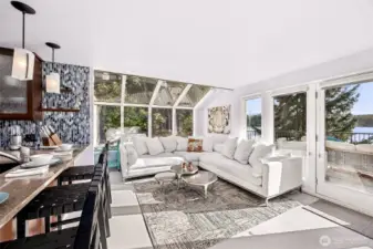 Entering the kitchen/great room space from the dinning room, the atrium window wall and front French doors fill the space with light and scenery.  A happy place for your favorite version of cozy.