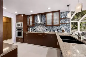 Stainless appliances and chef-style overhead venting, recessed lighting, and loads of storage between the kitchen and the pantry/utility space, all assist the cook with just the right of space in your kitchen work triangle.