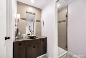 The main floor bath designed with dual entrances from the utility room and front hall that leads to the main floor bedroom, serves the purpose of day to day showering as you come off the beach and a handsome guest bath.