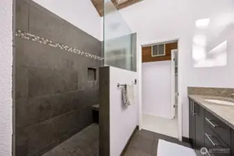 Wash away the day and disappear into this welcoming shower space.  Walk in closet across the primary suite hall in background.