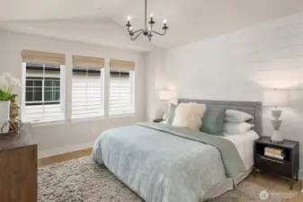 Primary bedroom retreat offering peaceful natural light and a comfortable, private setting with motorized blinds.