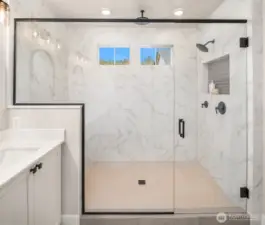 Oversized frameless glass shower with elegant tile surround and spa-like design.