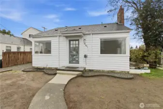 Front of home with parking along one side and gardening along the other. Seed is currently planted for the grass.