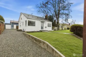 Front of home with gravel driveway and extra off-street parking. (Grass is virtual- seed is currently in the dirt)