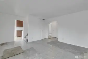 Living room with access to stairs and kitchen.