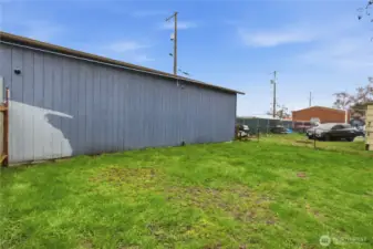 Fenced large backyard with natural grass.