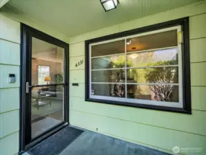 Welcoming entrance with wood storage and mail slot.