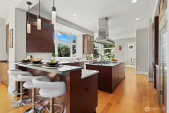 Large chef’s island kitchen with breakfast bar is equipped with top-tier Wolf, Miele, and SubZero appliances & walk-in pantry