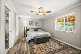 Primary suite with ceiling fan, walk in closet, and private en suite bath.