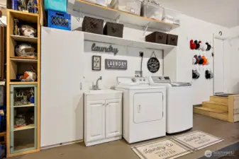 Organized laundry station.  Full size washer and dryer are included.  The white storage cabinets are also staying.