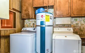 Washer, water heater, and dryer, located in the garage, with a cute passthrough from the mudroom