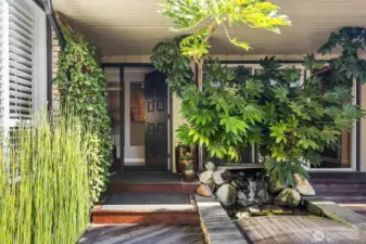 This area is several steps up from the street and tucked well back out of view.  The cute footbridge steps over the koi pond and leads to stairs down to the driveway.  Let's head inside...