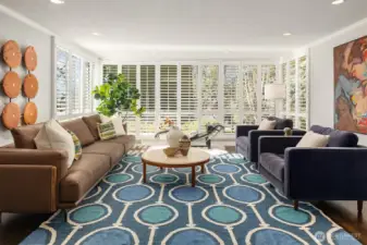 Floor-to-ceiling windows in the living room face north, west, and south; with mature evergreens across the street offering protection from late afternoon summer sun while allowing ample light to filter in throughout the day and throughout the year.