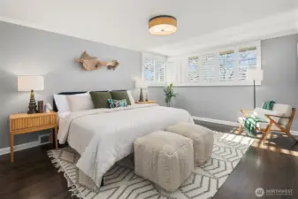 The SW-facing primary ensuite bedroom is very gracious is scale, easily accommodating a king bed with large side tables and additional seating.  A full bath is just behind where we're standing.