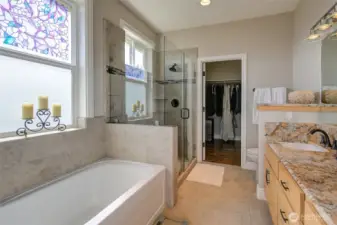Primary bathroom features a deep soaking tub, step in shower, and spacious walk in closet.
